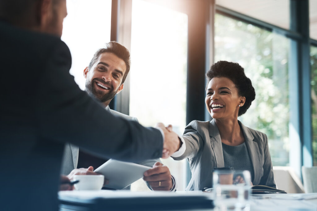 Accord professionnel entre une femme d’affaires et un entrepreneur lors d’une réunion, illustrant la collaboration et la confiance en gestion financière.